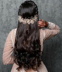 the back of a woman's head with long dark hair wearing a tiara