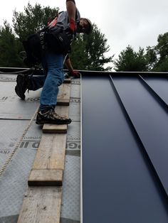 a man standing on top of a metal roof