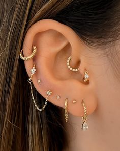 a woman's ear with three different types of piercings