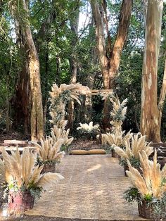 an outdoor wedding setup with flowers and greenery on the aisle, surrounded by trees