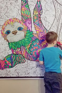 a young boy is drawing on the wall with colored pencils and an image of a slotty bear