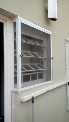 an empty shelf in the corner of a building with shutters open to let light inside