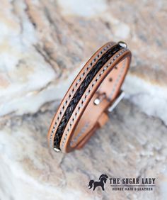 "This 1/2\" leather bracelet is made from European leather is hand stamped and hand stitched with horse hair inlaid into the leather. Perfect for the cowboy in your life! If you would like a different color thread or leather, just let me know and I'll be happy to make it happen. Please include your wrist size and whether you plan to use your own horse' s hair or hair from my own collection. I have a wide variety of colors to chose from. If using your own hair, tail hair of at least 10 inches of Horsehair Bracelet, Horse Hair Braiding, Horsehair Jewelry, Equine Jewelry, Hair Tail, Horse Hair Bracelet, Horse Hair Jewelry, Hair Bracelet, Tail Hair