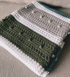 a crocheted blanket sitting on top of a couch