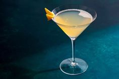 a martini glass with a lemon wedge on the rim