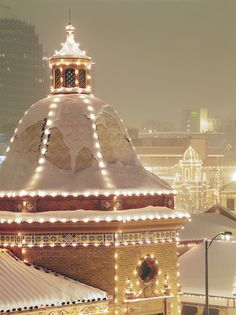 a clock tower covered in christmas lights on top of a building