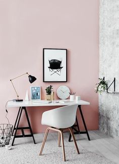 an image of a room with pink walls and white furniture in the corner, including a desk