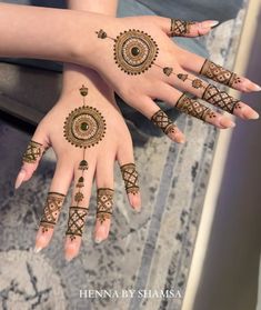 two hands with henna designs on them