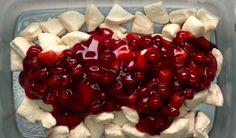 someone is spreading cherries on top of marshmallows in a glass dish