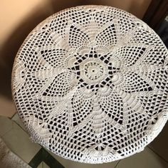 a white doily sitting on top of a wooden table