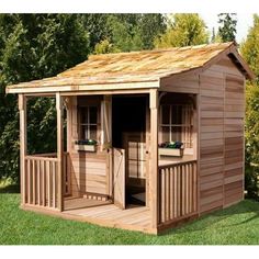 a wooden shed sitting on top of a lush green field