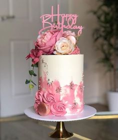 a white and pink cake with flowers on top