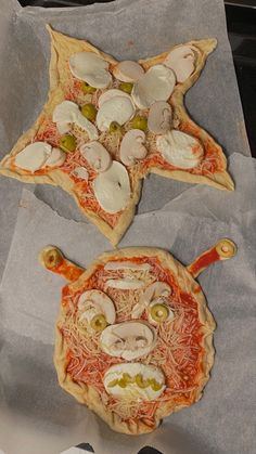 two pizzas with different toppings on top of paper