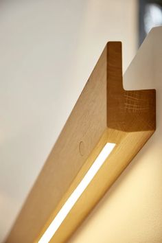 a close up of a light on a wall with a wooden beam in the middle