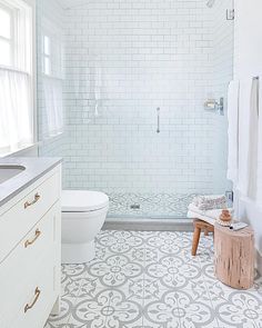 a bathroom with white and gray tiles on the floor