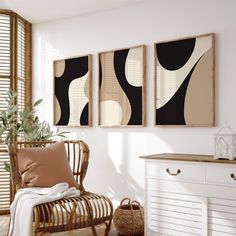 three paintings hang on the wall above a wicker chair in front of a white dresser