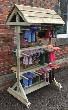 a wooden shoe rack with several pairs of shoes on it and a brick wall in the background