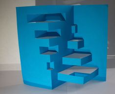 an abstract blue paper sculpture sitting on top of a table