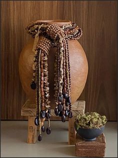 a wooden vase sitting next to a bunch of beads