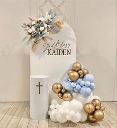 a bunch of balloons sitting on top of a table next to a white vase and cross