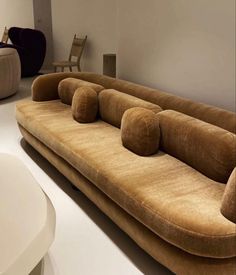 a large brown couch sitting on top of a white floor