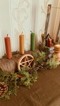 a table topped with candles and decorations on top of a brown cloth covered tablecloth