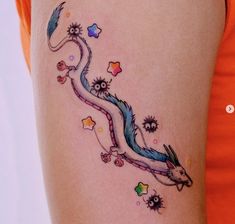 a woman's thigh with a colorful dragon tattoo on her left side ribcage