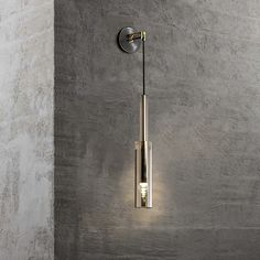 a modern light fixture on the side of a wall in a room with concrete walls