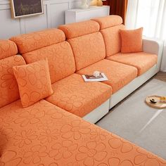 an orange couch sitting in the middle of a living room