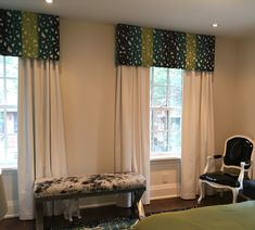 a bed room with a neatly made bed and two chairs next to the bedspread