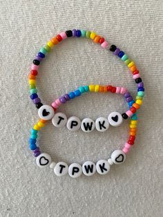 two bracelets with letters that spell out the word twk and qtwo