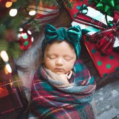 a baby wrapped in a blanket next to presents