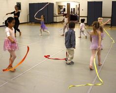 children are playing with ribbons in an indoor gym