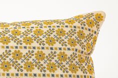 a yellow and blue pillow with flowers on it