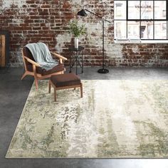 a living room with brick walls and an area rug that has a chair on it