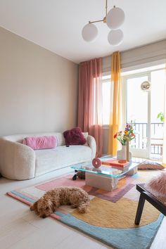 a living room filled with furniture and a dog laying on the floor next to it