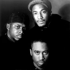 three men are posing for a black and white photo with one man looking at the camera