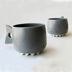 two gray cups sitting next to each other on a table