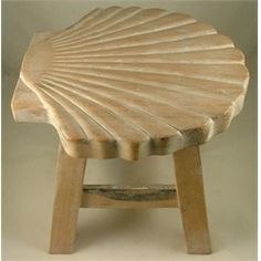 a small stool made out of wood with a shell design on the top and bottom