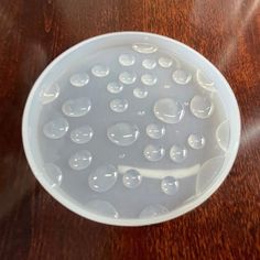 a white bowl filled with water on top of a wooden table