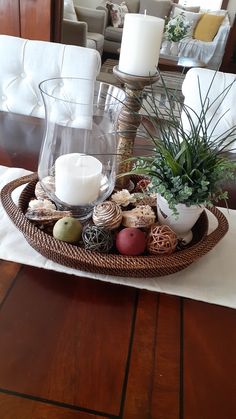 a tray with candles, rocks and plants on it