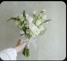 a person holding a bouquet of white flowers