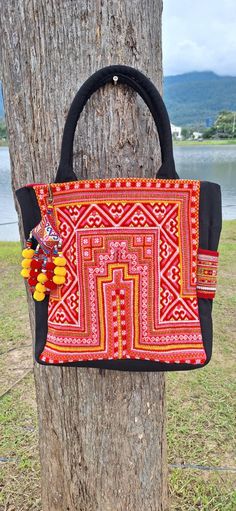 an orange and black bag hanging on a tree