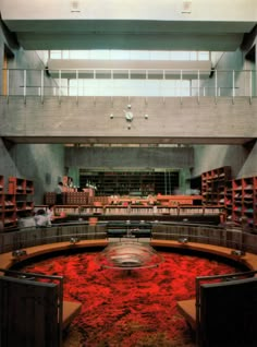 an empty library filled with lots of books and red dirt on the floor in front of it