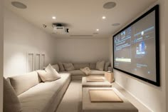 a living room filled with lots of furniture and a flat screen tv mounted to the wall