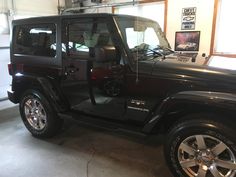 a black jeep is parked in a garage