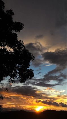 the sun is setting behind some trees