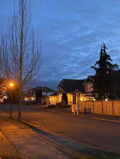 an empty street at night with houses in the background