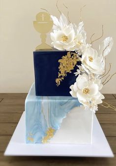 a blue and white cake with flowers on top