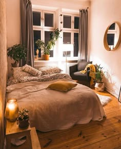 a bed room with a neatly made bed and some plants on the windows sill